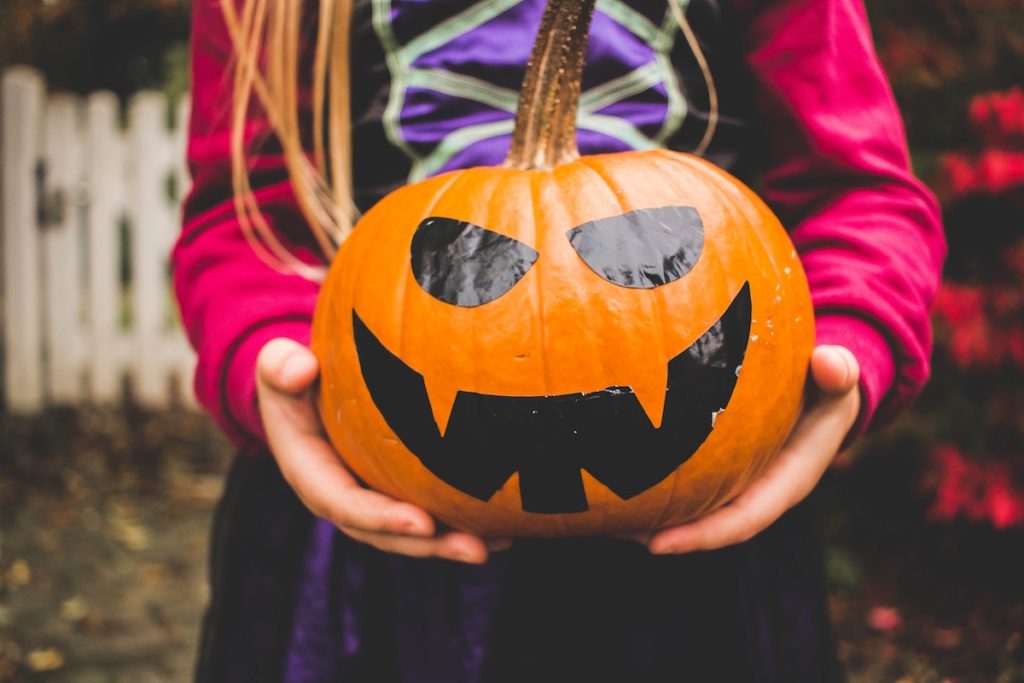 Young girl holding halloween pumpkin
