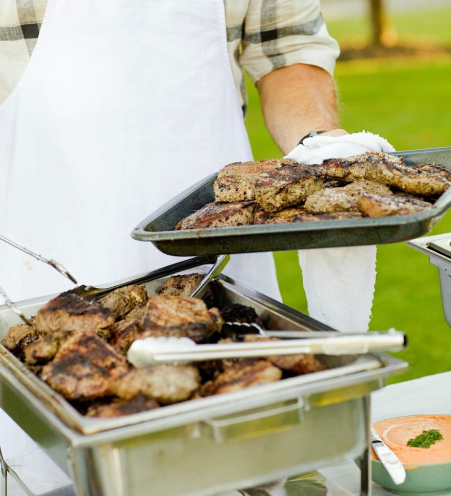 Caterer serving meat to guests